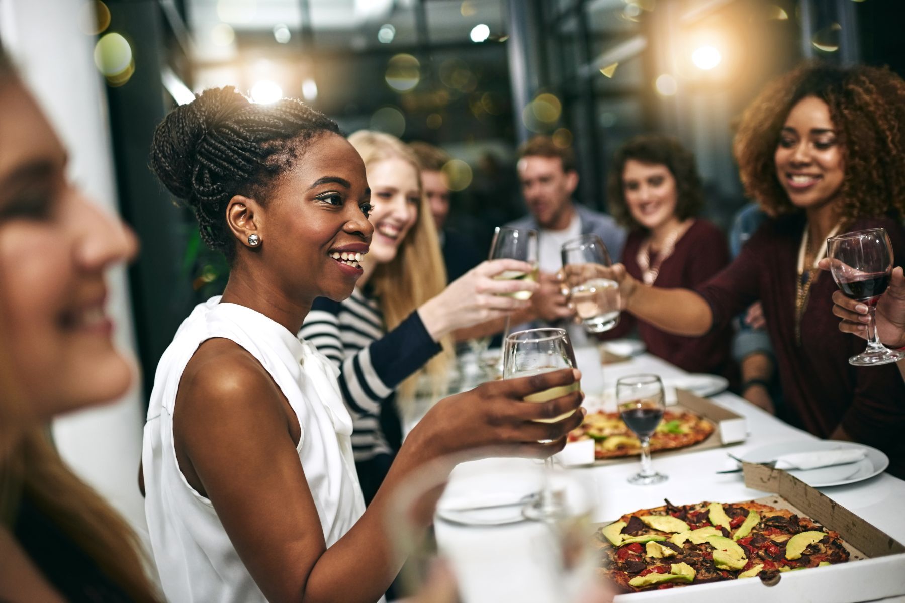 People sitting at a long table raising glasses and smiling