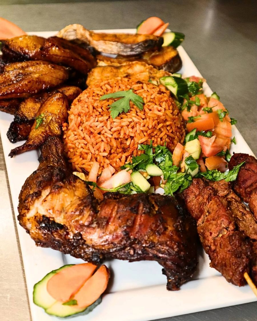 Rice surrounded by vegetables and skewered meat