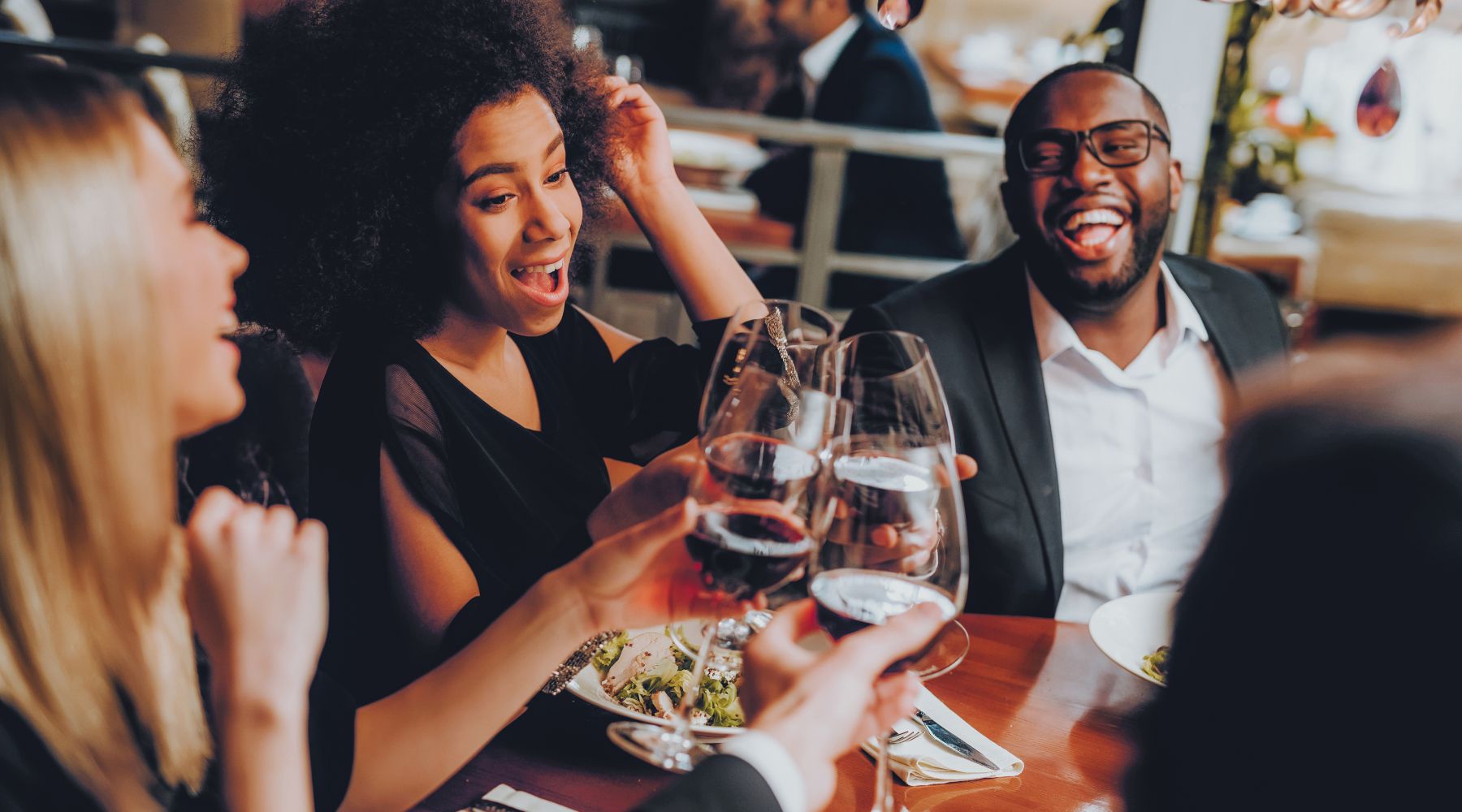 White woman and Black Man and Woman drinking wine and smiling