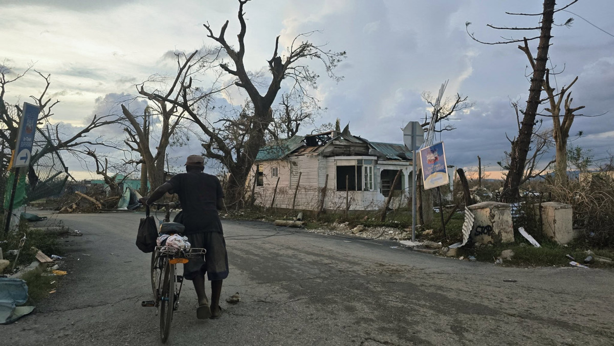 An elderly man walks his bicycle down a devastated street in Black River, Jamaica, after Hurricane Melissa, Josh Morgerman via Facebook.